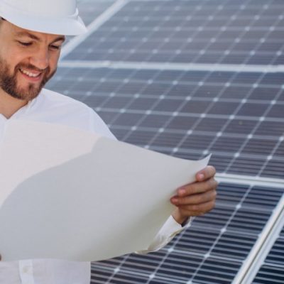 Young architect standing by solar panels